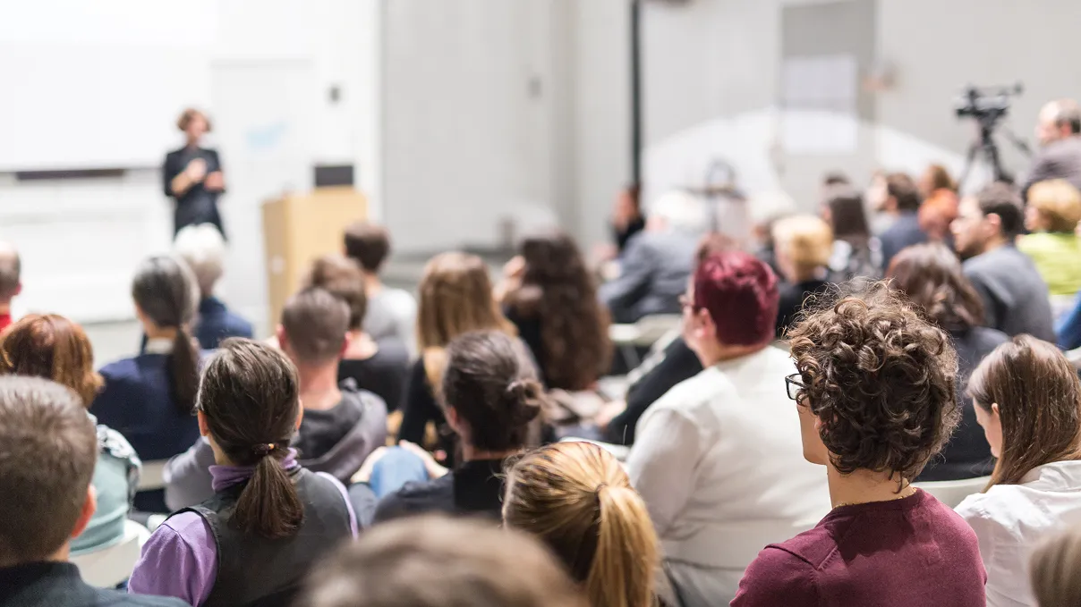 Hand reaching for a box of medication from a shelf in a pharmacy or medical storage unit.