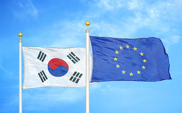 Flags of South Korea and the European Union waving side by side against a blue sky.