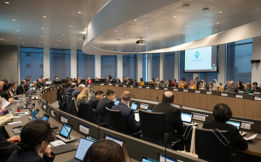 Wide view of delegates seated around a large circular table in a conference room at the EMA building during the ICMRA Summit 2025