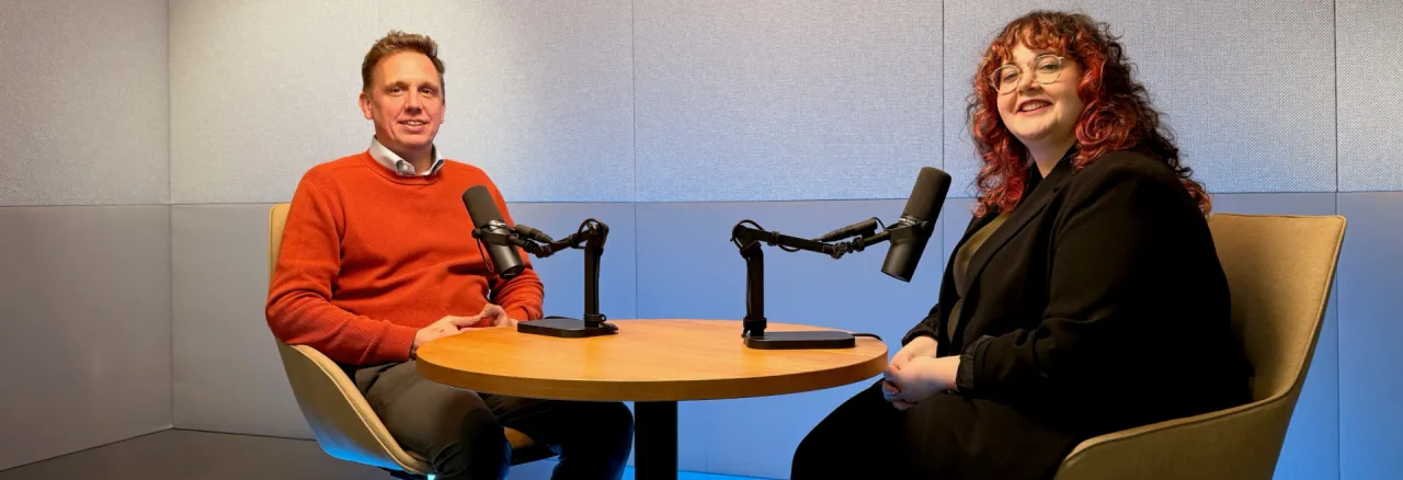 Two persons and podcast microphones