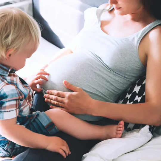 Pregnant woman with small child square