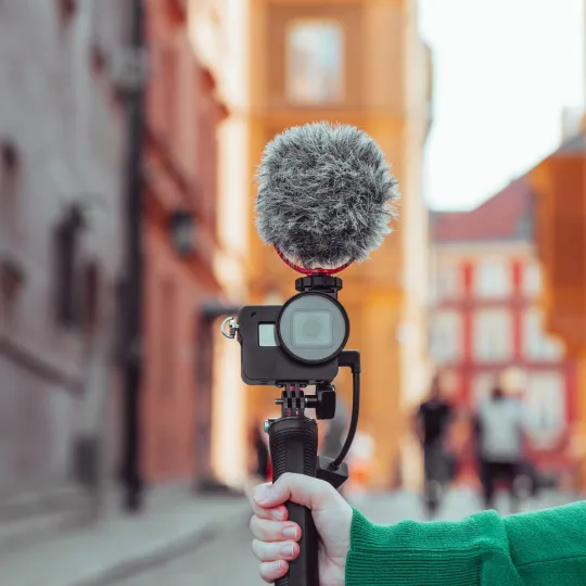 hand holding a camera with a microphone