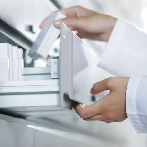 Pharmacist opening medicine drawer