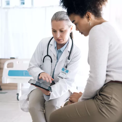 woman with stethoscope shows information to other woman