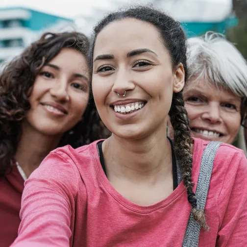 A diverse group of four women smiling together in support for Women's Health Day